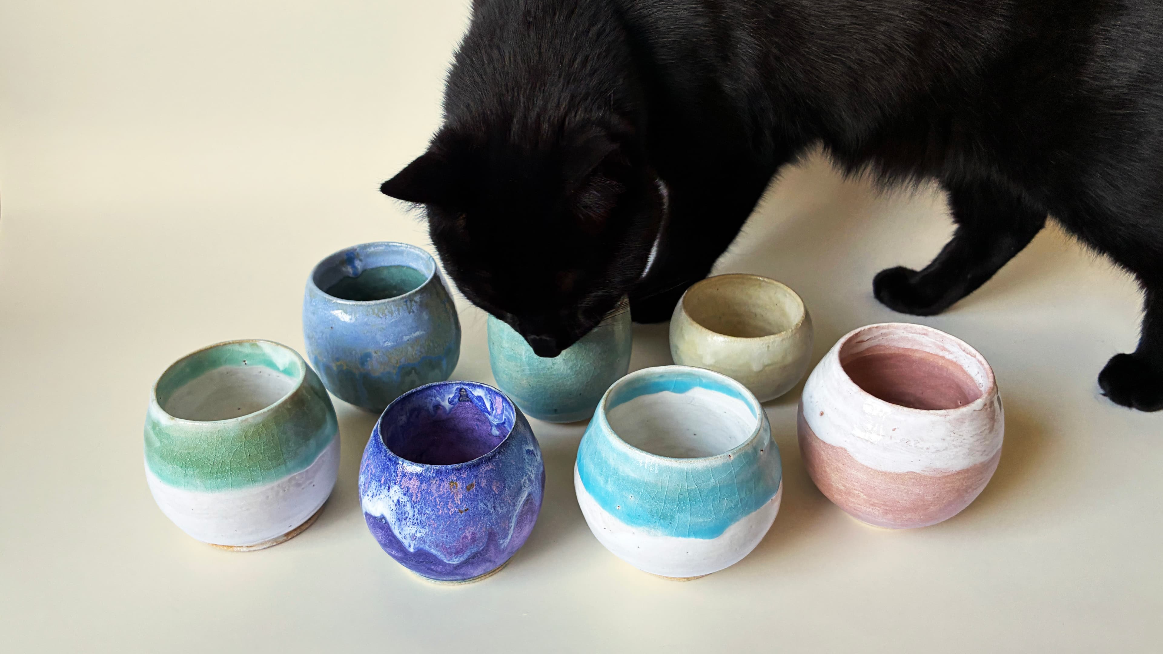 Handmade ceramic teapots with animal-shaped lids arranged in a studio display.